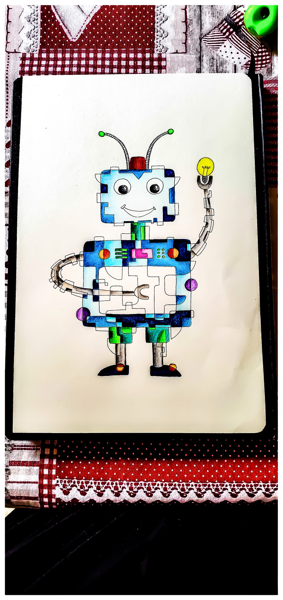 Dessin aux crayons de couleur d'un robot enfantin imaginaire. Les couleurs utilisées sont le bleu, le rouge et le vert. Le robot est souriant. 